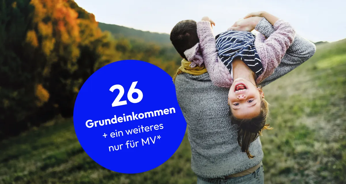 Ein großer Schriftzug "26 Grundeinkommen, plus ein weiteres nur für MV". Daneben trägt ein Mann seine lachende Tochter auf seiner Schulter, während er über eine Wiese geht.